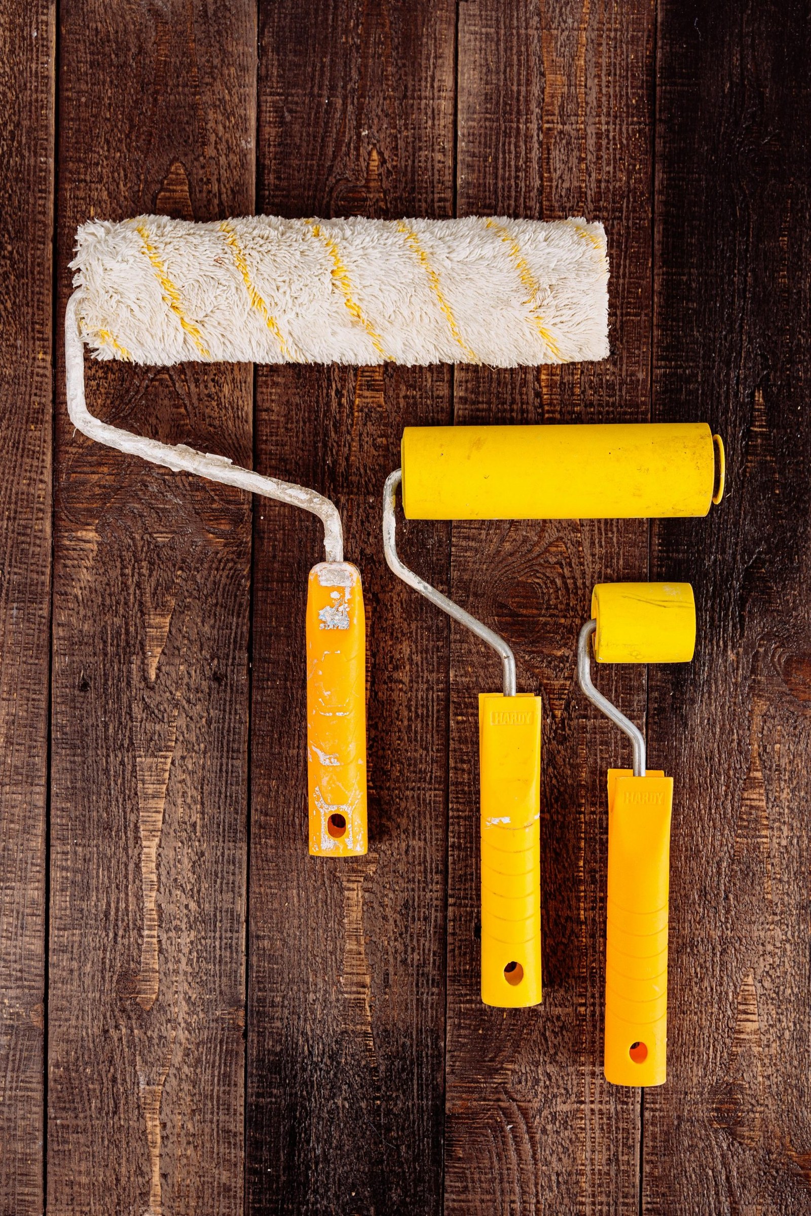 Paint rollers arranged on a wooden background